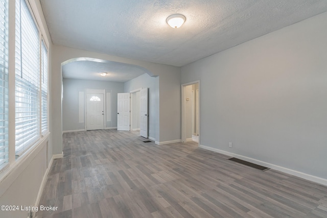 spare room with a textured ceiling and hardwood / wood-style floors