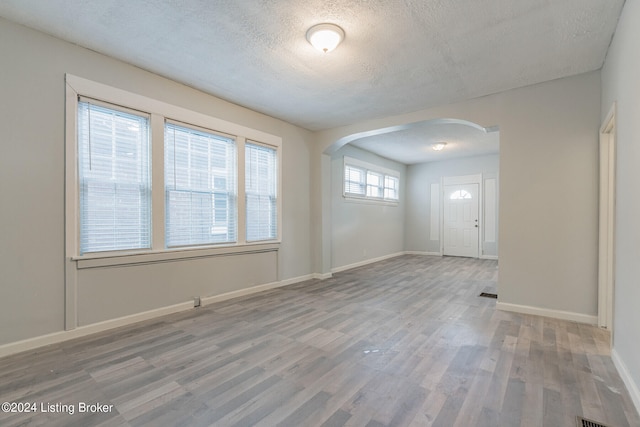 spare room with a textured ceiling and hardwood / wood-style flooring