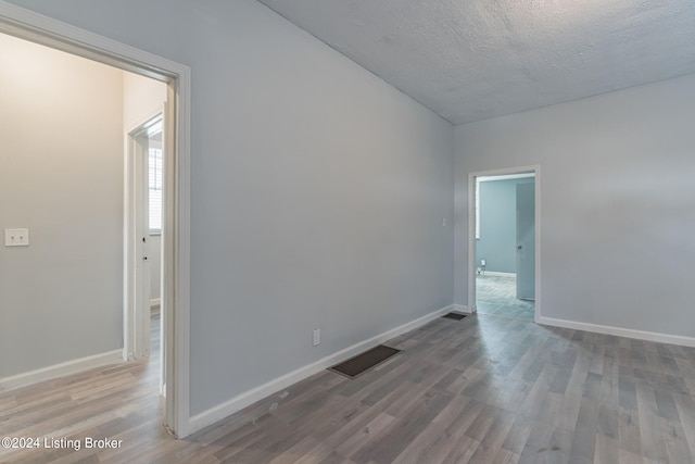 spare room with hardwood / wood-style flooring and a textured ceiling