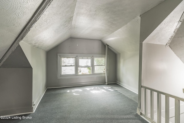 additional living space with a textured ceiling, carpet flooring, and vaulted ceiling