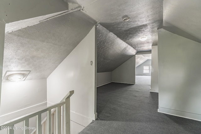 bonus room with dark carpet, a textured ceiling, and vaulted ceiling