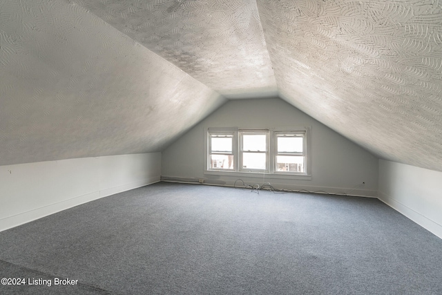 bonus room with lofted ceiling, a textured ceiling, and carpet flooring