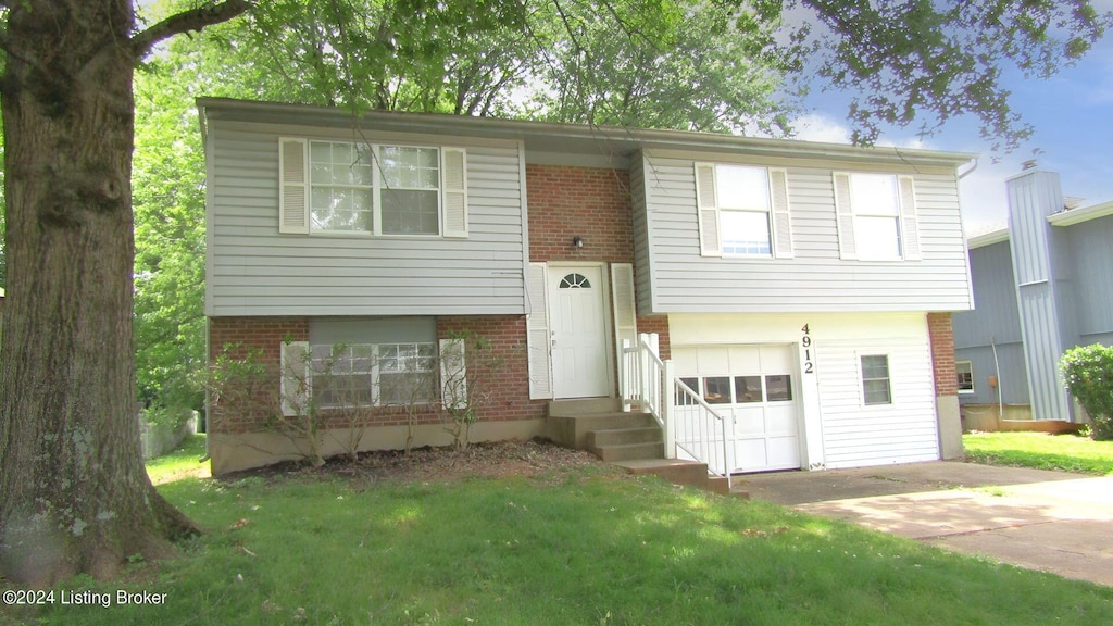 split foyer home featuring a garage and a front lawn