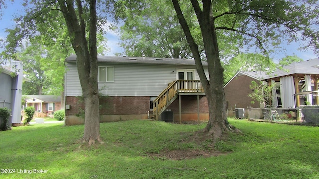 rear view of house with cooling unit and a yard