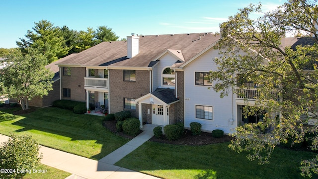 townhome / multi-family property featuring a balcony and a front lawn