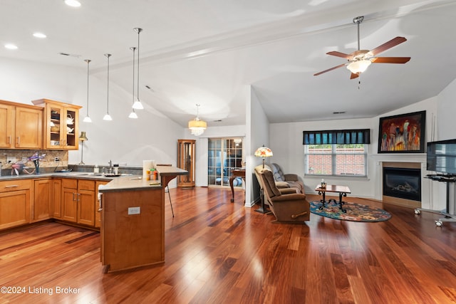 kitchen with hardwood / wood-style flooring, decorative light fixtures, tasteful backsplash, and lofted ceiling