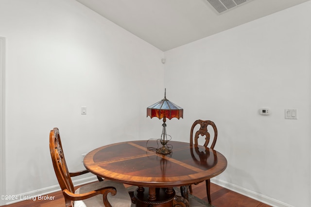 dining area with hardwood / wood-style flooring and vaulted ceiling