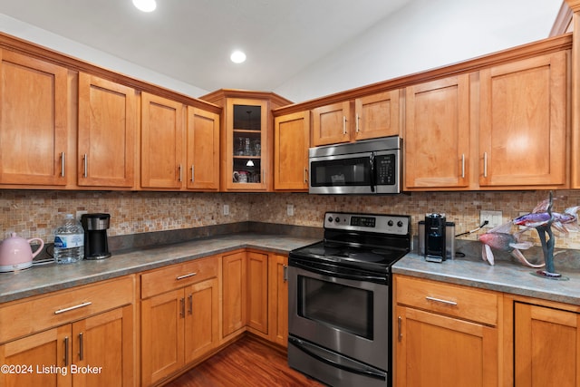 kitchen with stainless steel appliances, dark wood-type flooring, tasteful backsplash, and lofted ceiling