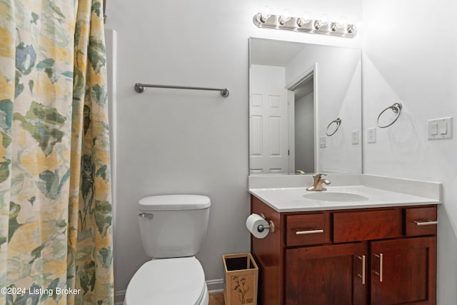 bathroom with curtained shower, vanity, and toilet