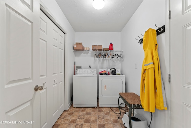 washroom with a textured ceiling and independent washer and dryer