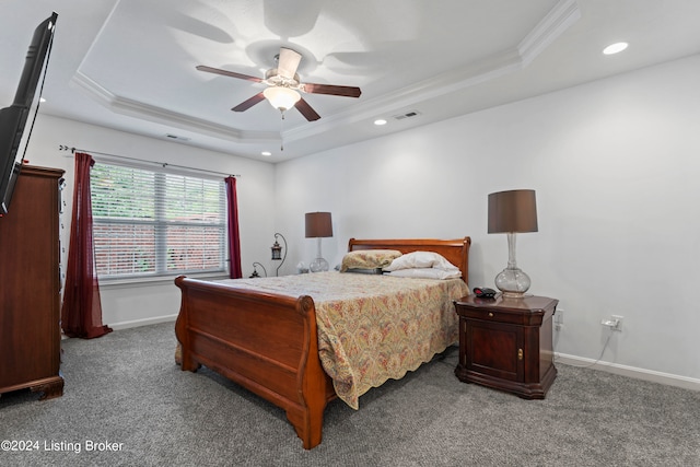 carpeted bedroom featuring a tray ceiling, ceiling fan, and crown molding