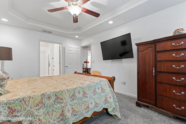 bedroom with ceiling fan, a tray ceiling, light carpet, and ornamental molding