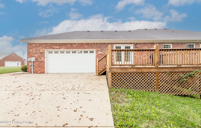 back of property with a garage and a wooden deck