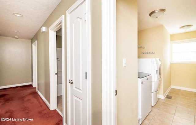 hall featuring washing machine and dryer and light tile patterned floors