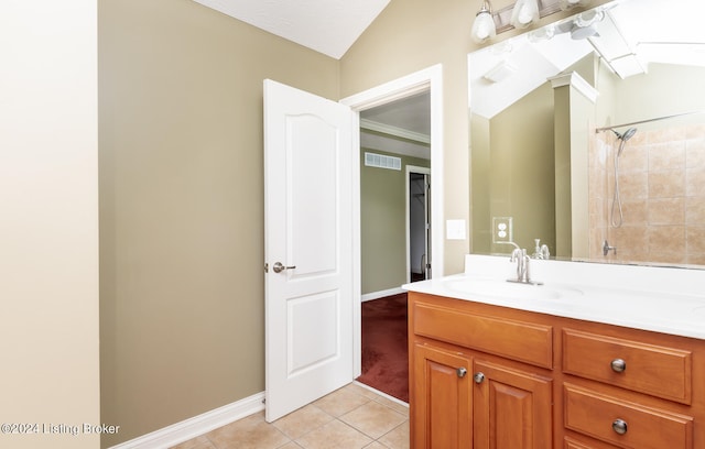 bathroom with tile patterned flooring, vanity, and vaulted ceiling