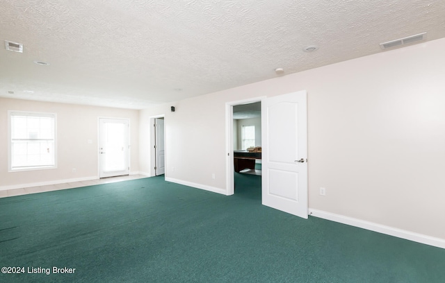 carpeted spare room featuring a textured ceiling