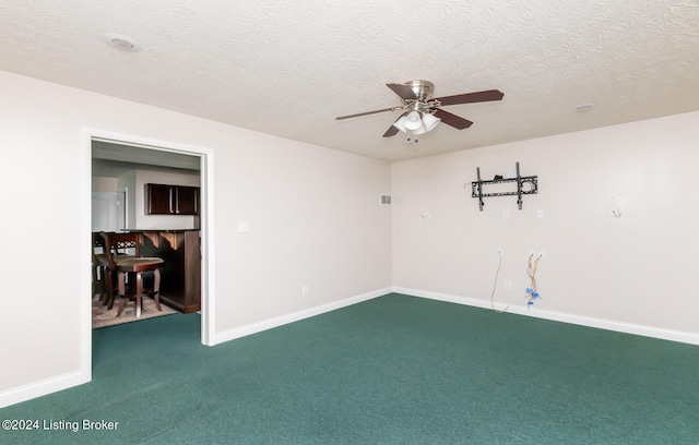 carpeted empty room with ceiling fan and a textured ceiling