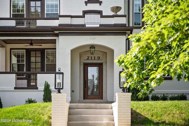 property entrance with a balcony and ceiling fan