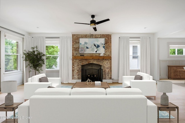 living room with ceiling fan, light hardwood / wood-style floors, and a fireplace