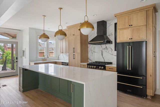 kitchen with wall chimney exhaust hood, a wealth of natural light, a center island, and high end fridge