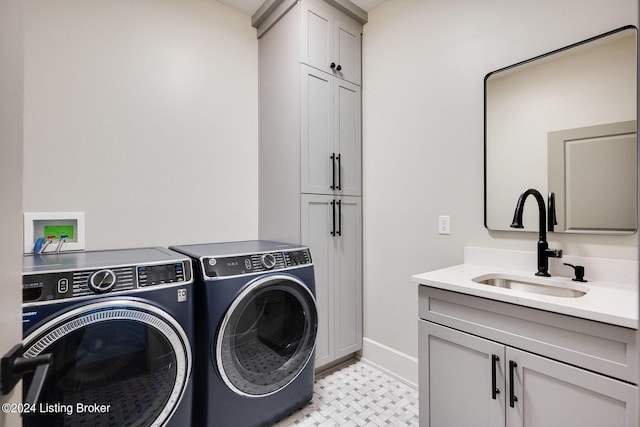 washroom with cabinets, sink, and washer and dryer