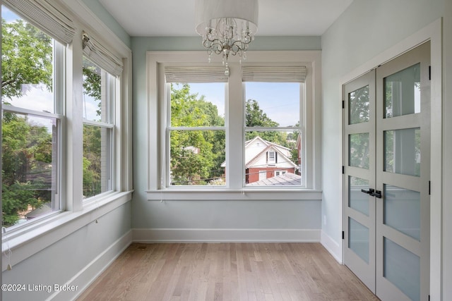 unfurnished sunroom featuring a notable chandelier and a wealth of natural light