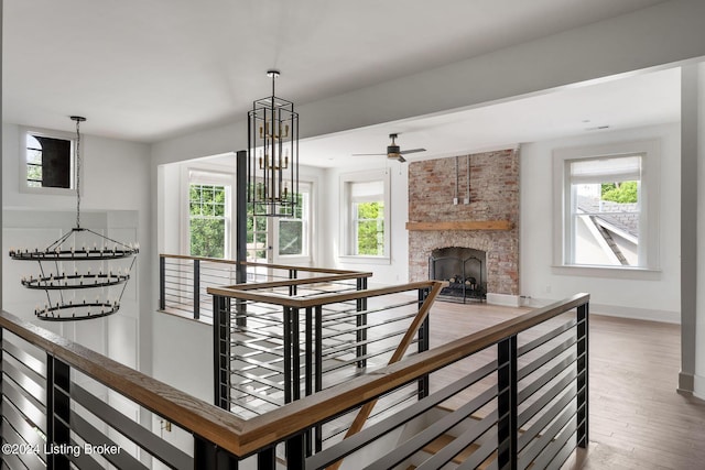 corridor featuring a chandelier, hardwood / wood-style flooring, and a healthy amount of sunlight