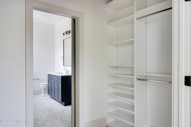 walk in closet with light tile patterned flooring and sink