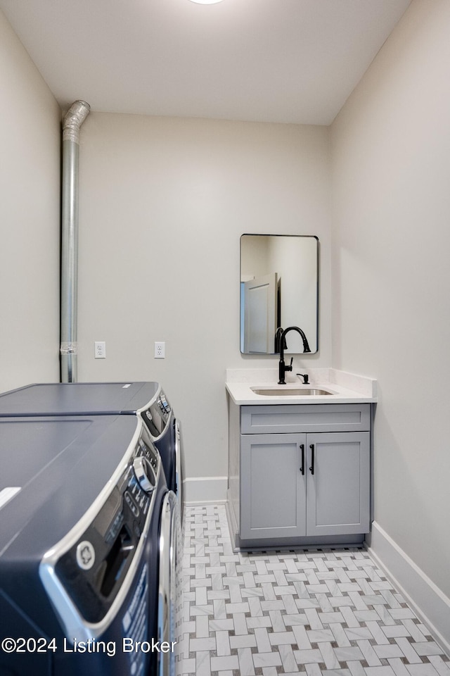 clothes washing area with cabinets, washer and dryer, and sink