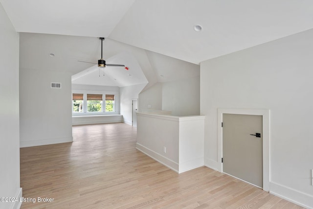 corridor with vaulted ceiling and light hardwood / wood-style floors