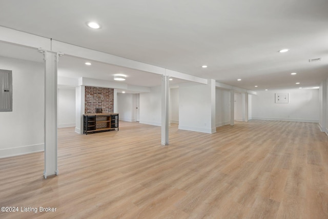 basement featuring light hardwood / wood-style floors and electric panel