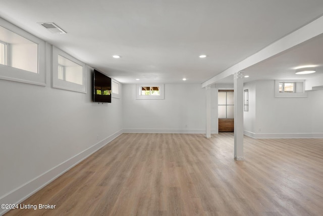 basement with light wood-type flooring and a wealth of natural light