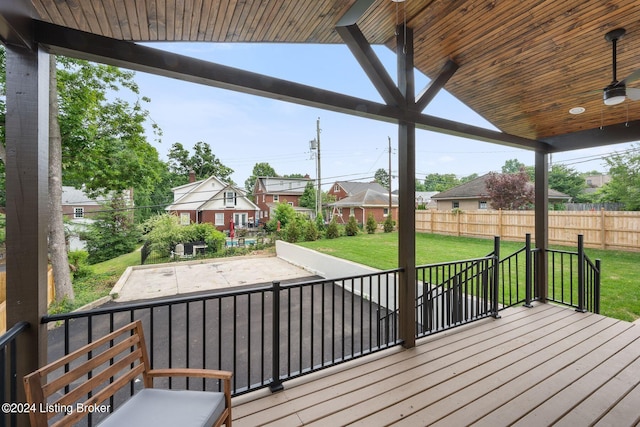 wooden terrace featuring a lawn, ceiling fan, and a patio area