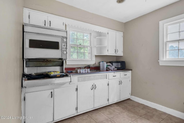 kitchen with white cabinets and light tile patterned floors