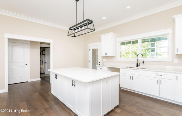 kitchen featuring white cabinetry, sink, dark hardwood / wood-style flooring, a kitchen island, and ornamental molding