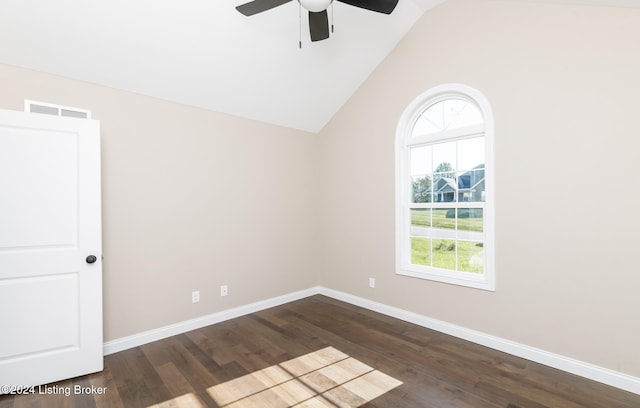 spare room featuring dark hardwood / wood-style floors, vaulted ceiling, and ceiling fan