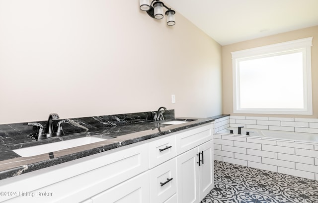 bathroom with tile patterned flooring, vanity, and tiled tub