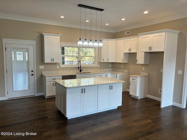 kitchen featuring a center island, dark wood-type flooring, white cabinets, sink, and decorative light fixtures