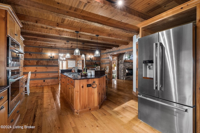 kitchen featuring pendant lighting, light hardwood / wood-style floors, beamed ceiling, and appliances with stainless steel finishes