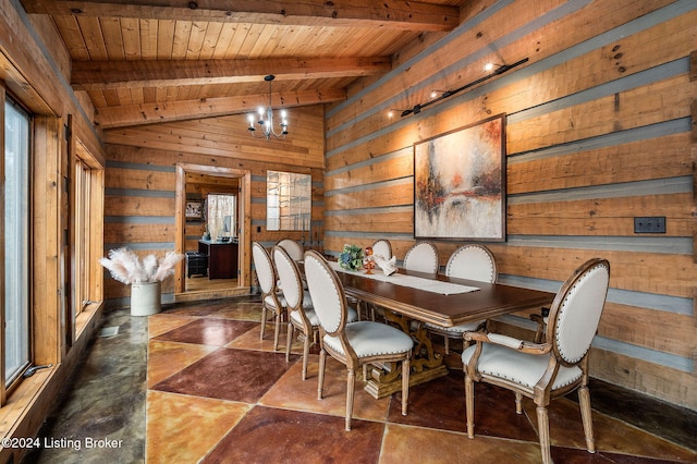 dining area featuring lofted ceiling with beams, wood walls, plenty of natural light, and an inviting chandelier