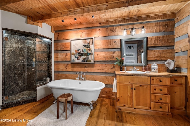 bathroom with beamed ceiling, wood-type flooring, wooden ceiling, and a tub