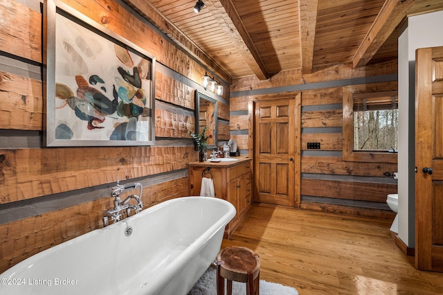 bathroom with a tub to relax in, wood walls, hardwood / wood-style floors, and toilet