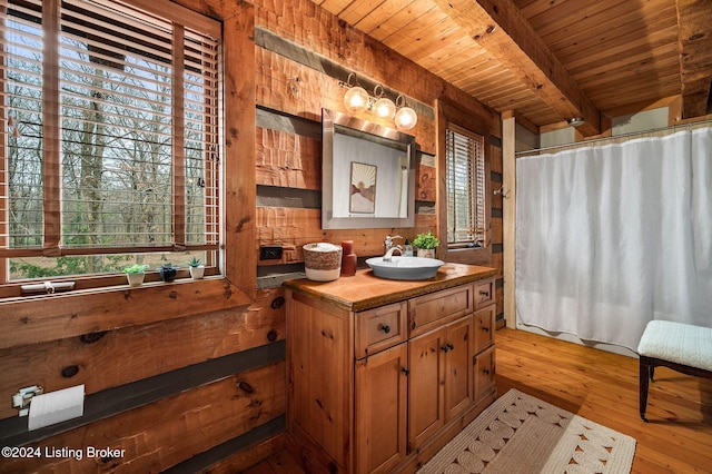 bathroom featuring beam ceiling, hardwood / wood-style floors, vanity, and wood ceiling