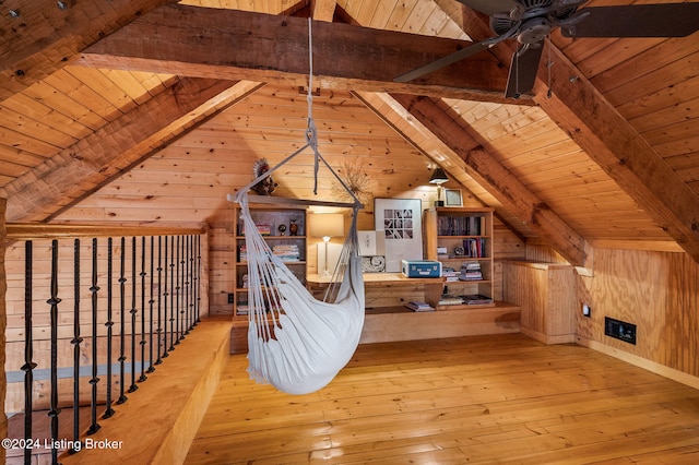 additional living space with lofted ceiling with beams, wooden walls, wood ceiling, and light hardwood / wood-style floors