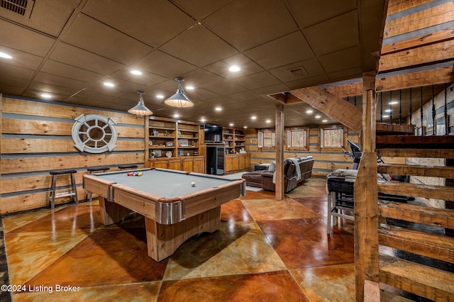 recreation room featuring wooden walls, a drop ceiling, and billiards