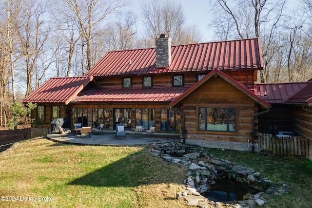 back of property featuring a lawn and a patio