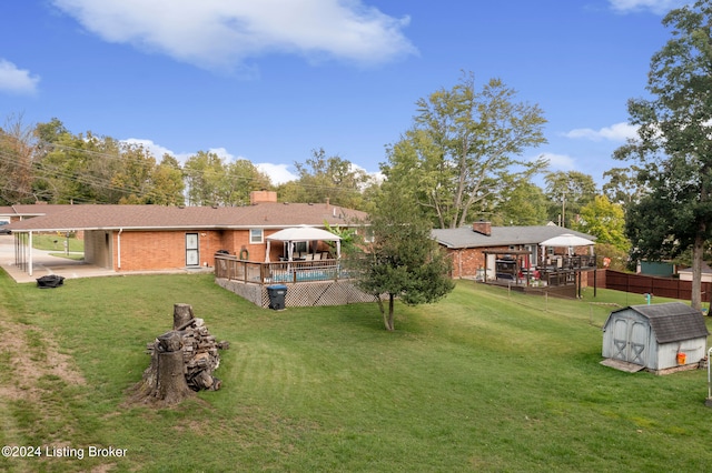 view of yard with a storage unit, a patio, and a swimming pool side deck