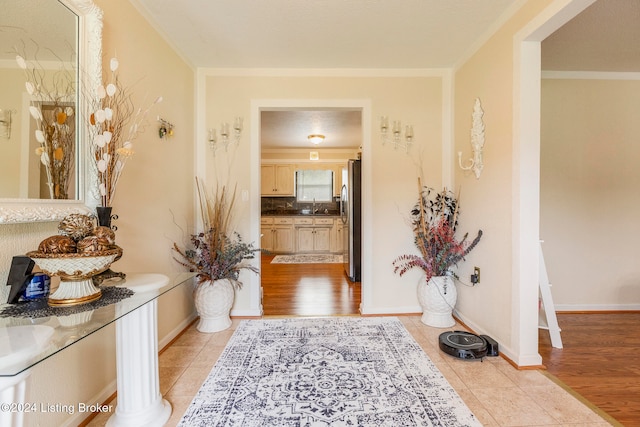 bathroom featuring ornamental molding, hardwood / wood-style flooring, tasteful backsplash, and sink