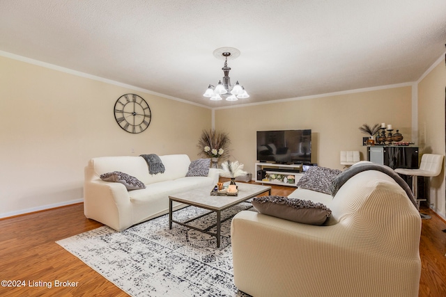 living room with wood-type flooring, a notable chandelier, and ornamental molding