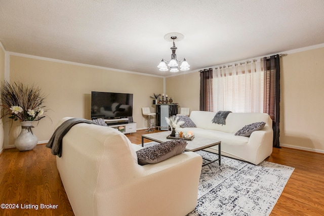 living room featuring wood-type flooring, crown molding, and a notable chandelier